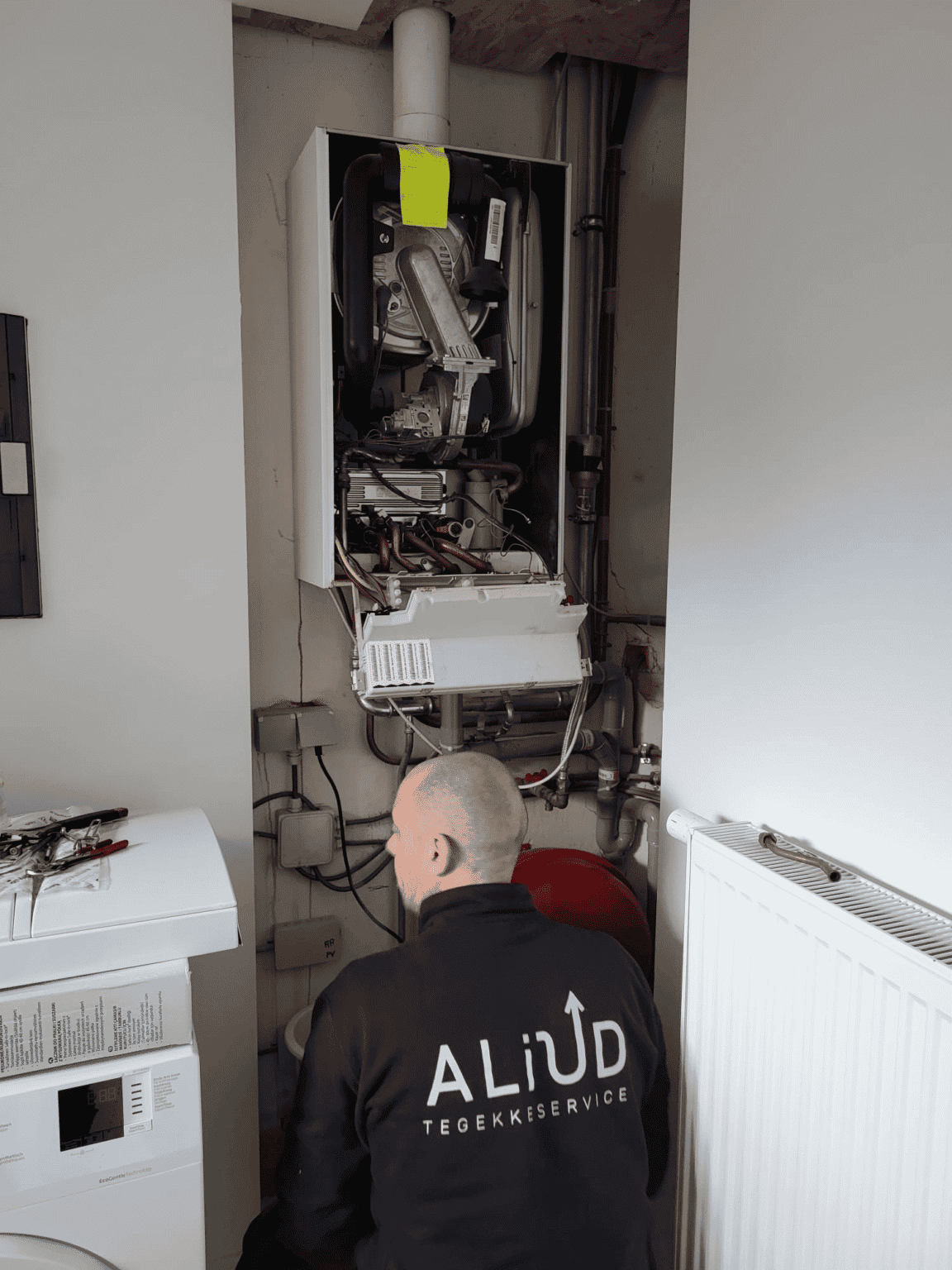 Technieker van Aliud die een particulieren gasketel nakijkt.