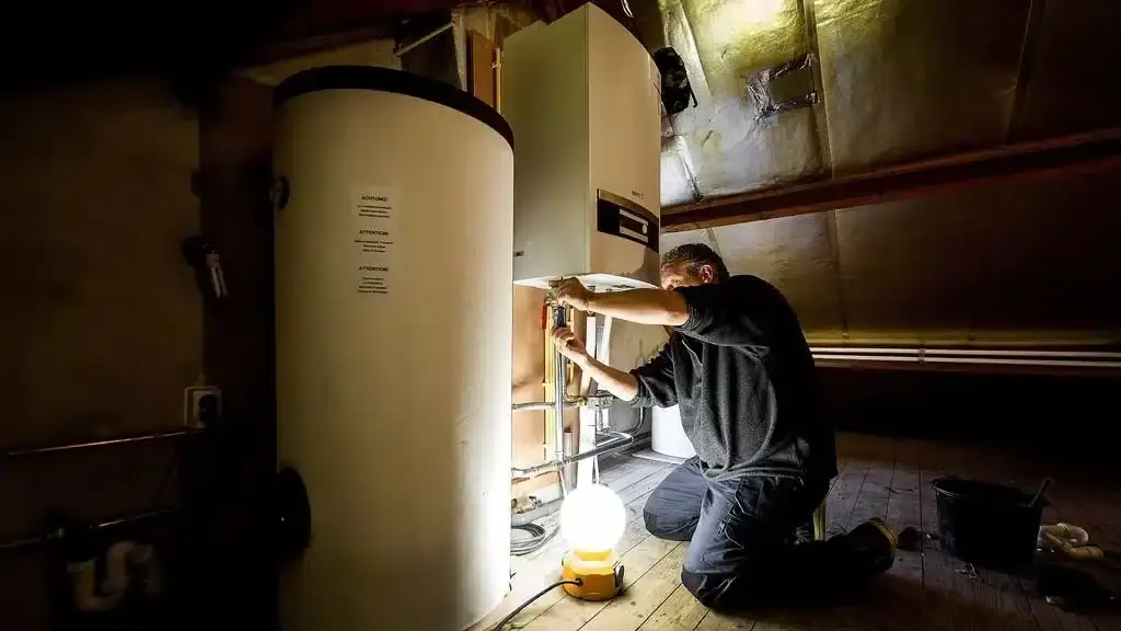 Aliud techniekmedewerker die een boiler nakijkt of installeert